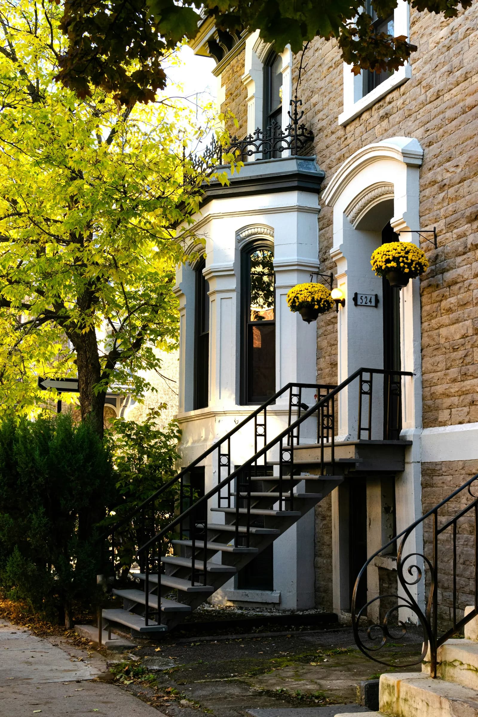 Entrée et escalier d’une maison montréalaise à façade de pierre.